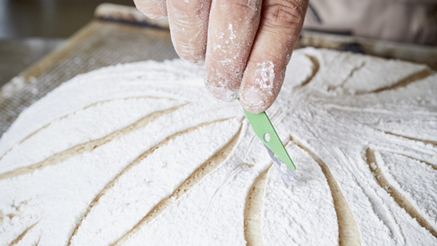 Vue Rapprochée Du Boulanger Coupant La Pâte à Pain Avec Un Grattoir En  Acier Dans La Boulangerie