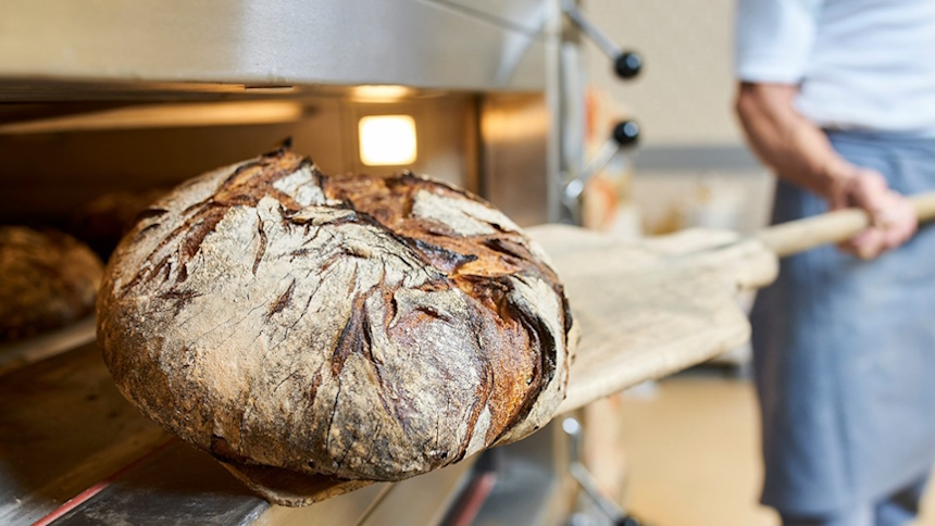 Frisch gebackenes Brot wird aus dem Ofen genommen