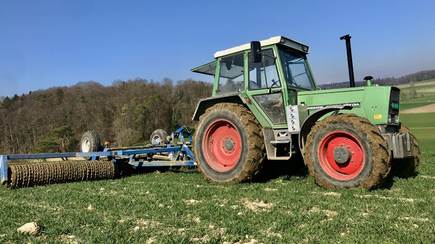 Walze mit Traktor auf Weizenfeld